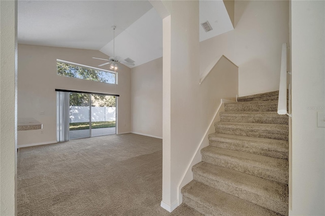 stairway with carpet floors, high vaulted ceiling, and ceiling fan