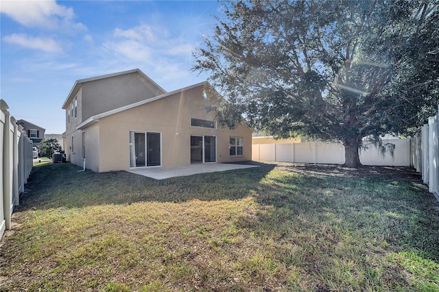 rear view of property with cooling unit, a yard, and a patio