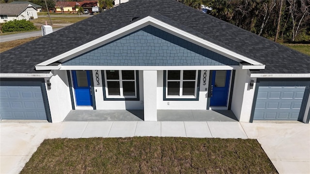 ranch-style home featuring a garage, a front yard, and covered porch