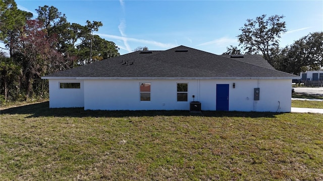 rear view of property featuring a lawn