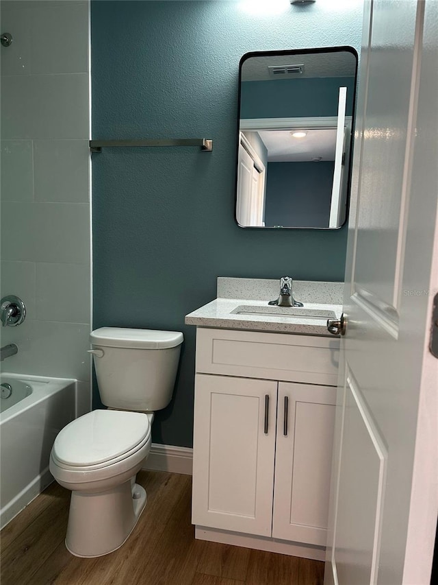 full bathroom with wood-type flooring, toilet, shower / bathing tub combination, and vanity