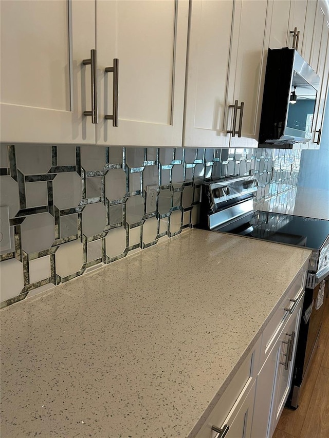 details with white cabinetry, appliances with stainless steel finishes, light stone countertops, and decorative backsplash