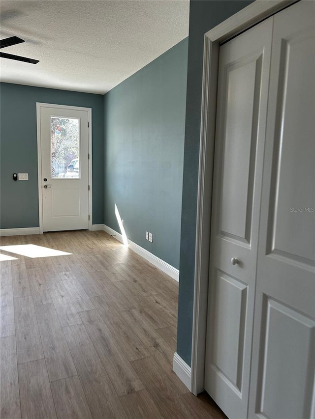 entryway featuring ceiling fan, a textured ceiling, and light hardwood / wood-style floors