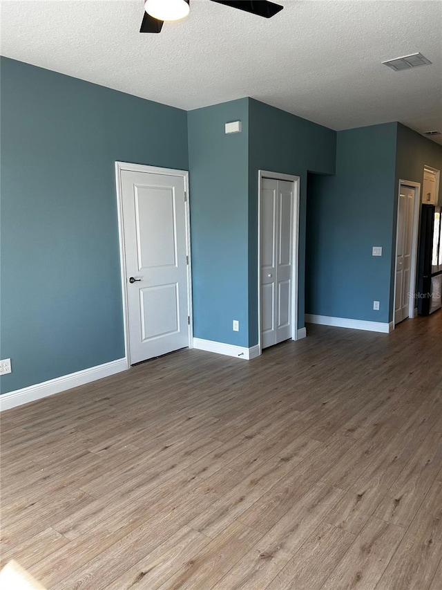 spare room featuring ceiling fan, a textured ceiling, and light wood-type flooring