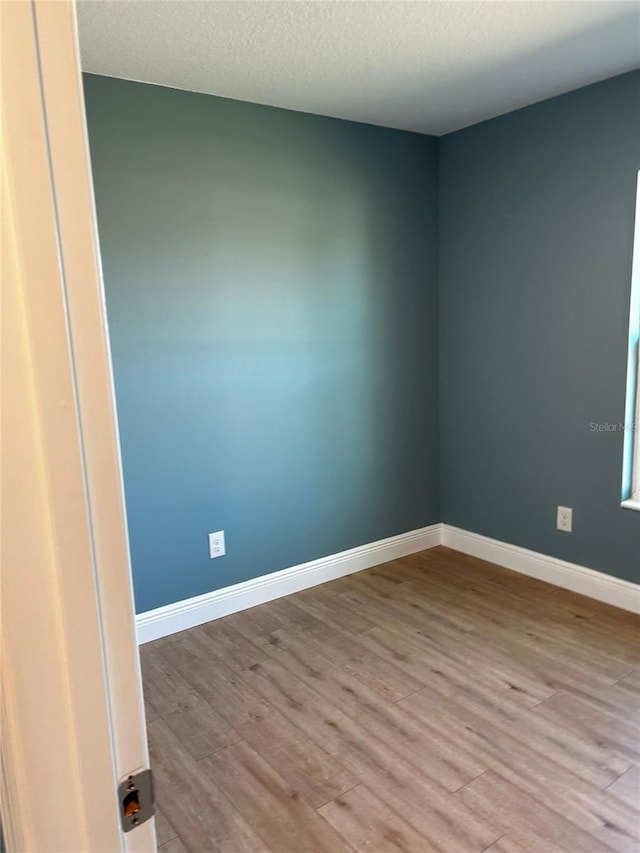 empty room featuring a textured ceiling and light wood-type flooring