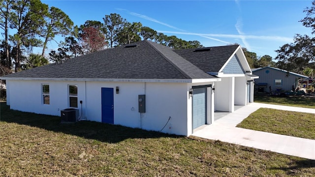 view of home's exterior featuring a garage, a lawn, and central air condition unit