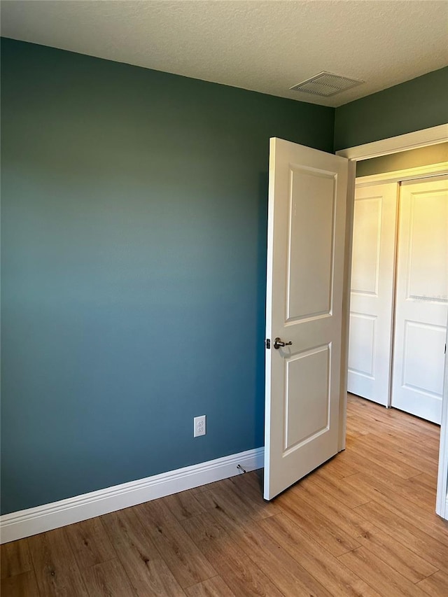 unfurnished bedroom featuring light hardwood / wood-style flooring and a textured ceiling