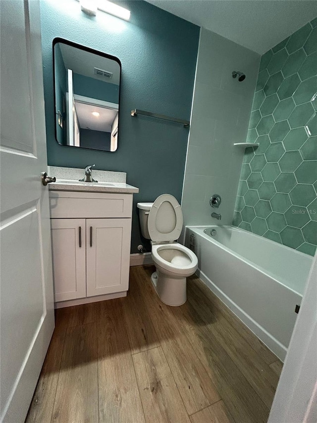 full bathroom with vanity, hardwood / wood-style flooring, toilet, and washtub / shower combination