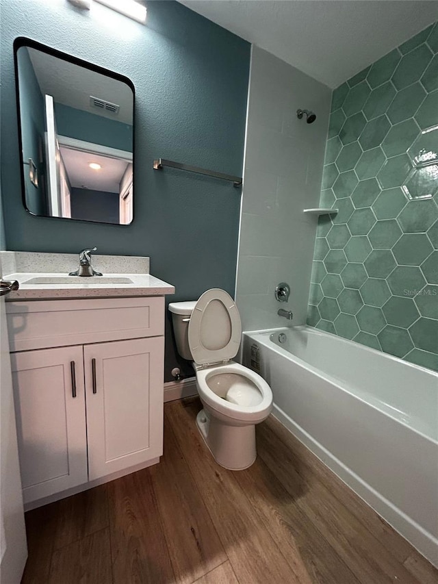 full bathroom with  shower combination, hardwood / wood-style floors, vanity, and toilet