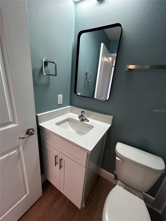 bathroom featuring hardwood / wood-style flooring, vanity, and toilet