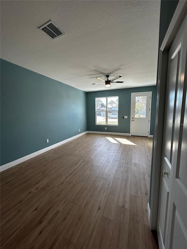 spare room with hardwood / wood-style flooring, ceiling fan, and a textured ceiling