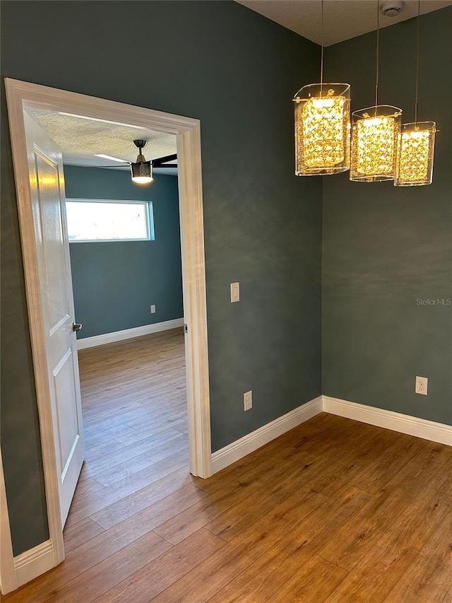 unfurnished dining area featuring hardwood / wood-style flooring and a notable chandelier