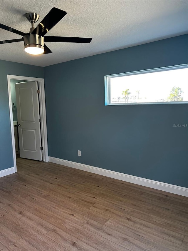 unfurnished room featuring a textured ceiling, ceiling fan, and light wood-type flooring