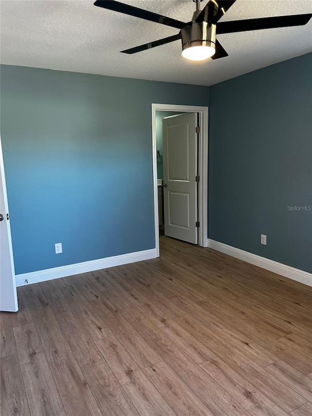 unfurnished room featuring ceiling fan, a textured ceiling, and light wood-type flooring