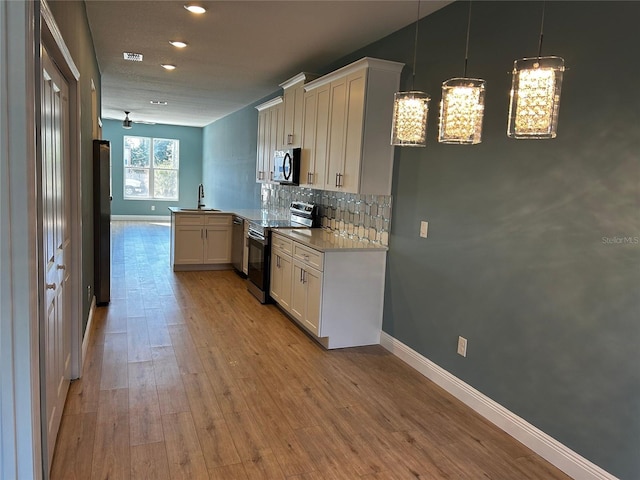 kitchen with tasteful backsplash, white cabinetry, stainless steel appliances, and kitchen peninsula