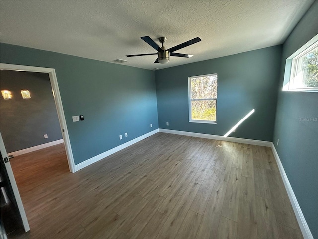 unfurnished room with hardwood / wood-style flooring, ceiling fan, and a textured ceiling