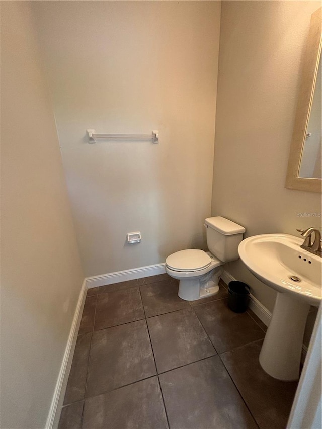 bathroom featuring sink, tile patterned floors, and toilet