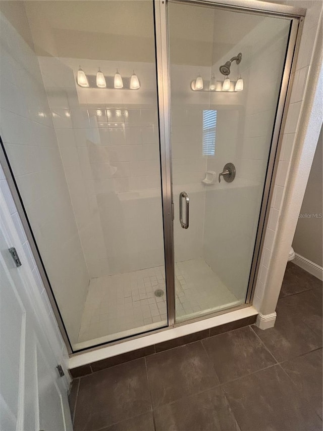 bathroom featuring a shower with door and tile patterned flooring