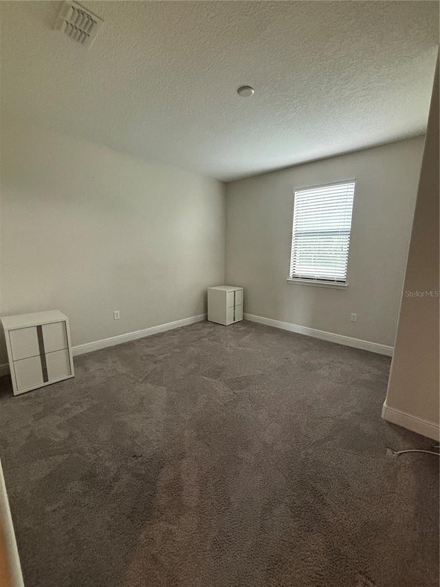 carpeted spare room featuring a textured ceiling