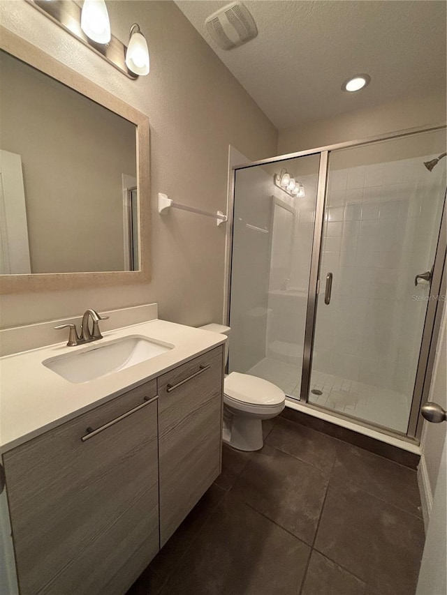 bathroom featuring vanity, an enclosed shower, tile patterned floors, and toilet