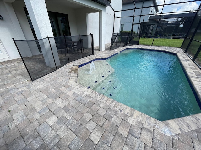 view of pool with a lanai, pool water feature, and a patio area