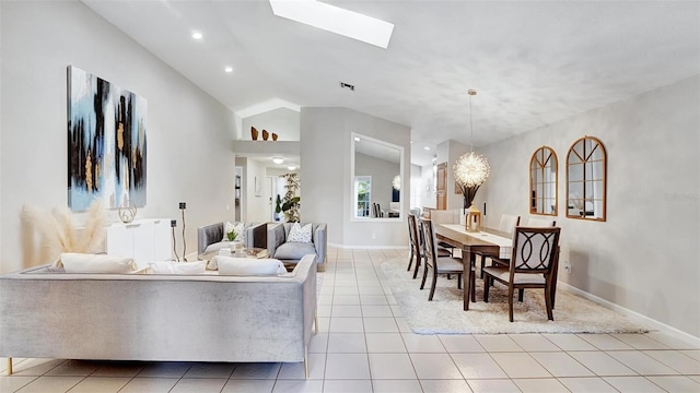 living room featuring light tile patterned flooring, lofted ceiling with skylight, and a chandelier