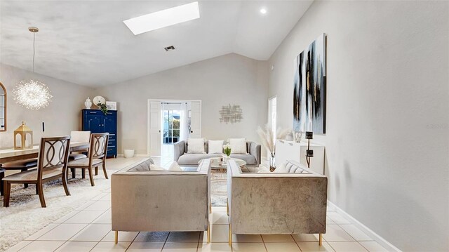 tiled living room with lofted ceiling with skylight and an inviting chandelier