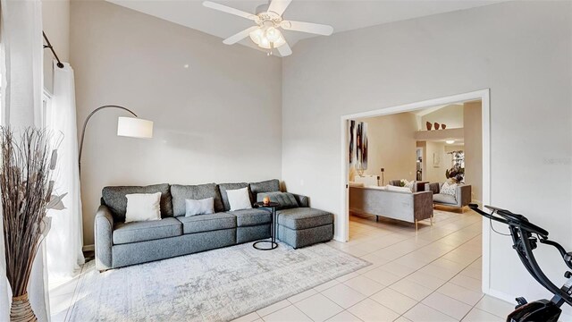 living room featuring vaulted ceiling, ceiling fan, and light tile patterned flooring