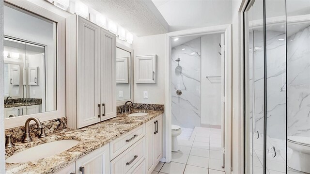 bathroom with toilet, a shower with shower door, and a textured ceiling