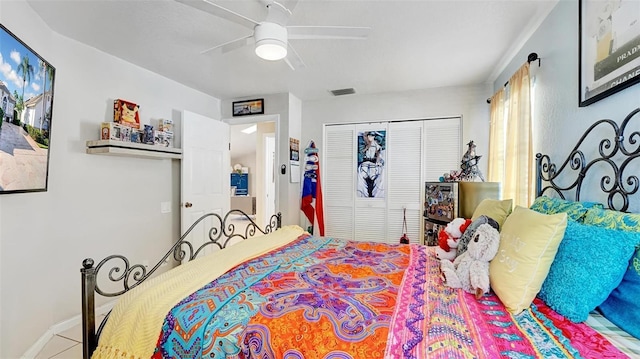 bedroom with tile patterned floors, ceiling fan, and a closet