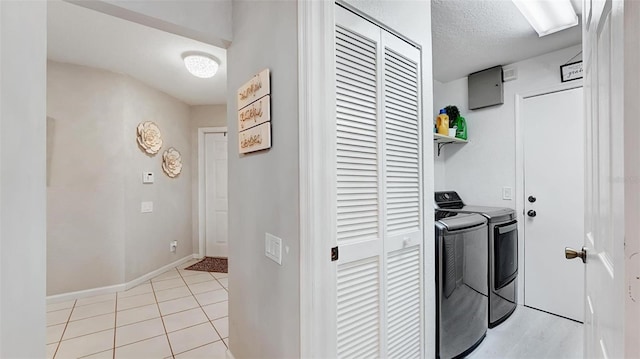 laundry area with light tile patterned flooring, independent washer and dryer, and a textured ceiling