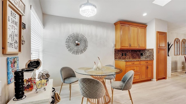 dining area with a notable chandelier and light hardwood / wood-style flooring