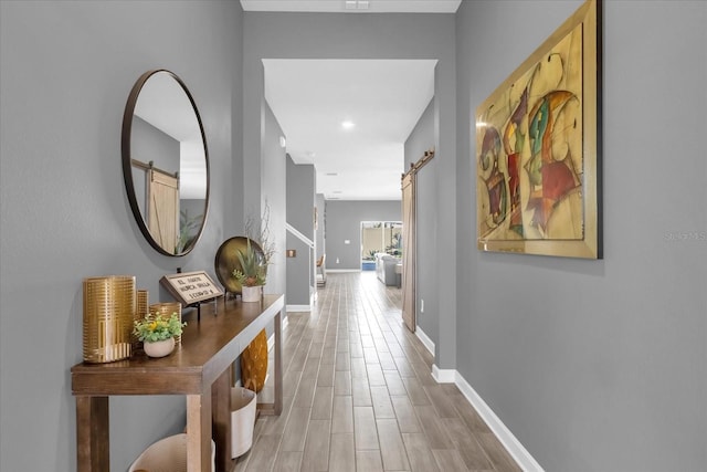 hallway featuring a barn door and hardwood / wood-style floors