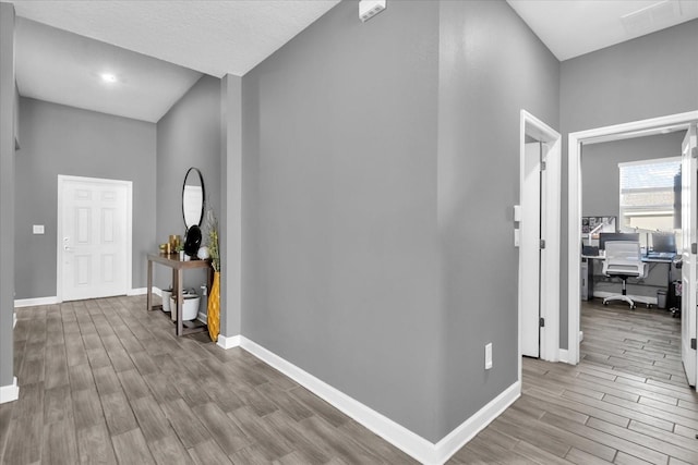 hallway with a high ceiling and light wood-type flooring