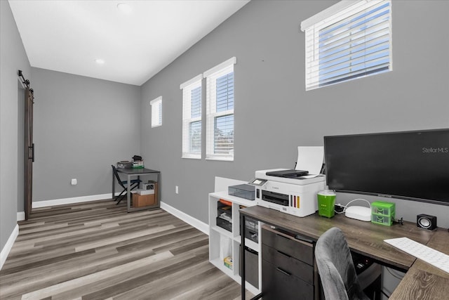 office area featuring wood-type flooring and a barn door