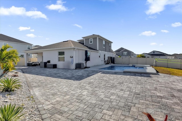 back of house featuring a fenced in pool, central AC unit, and a patio