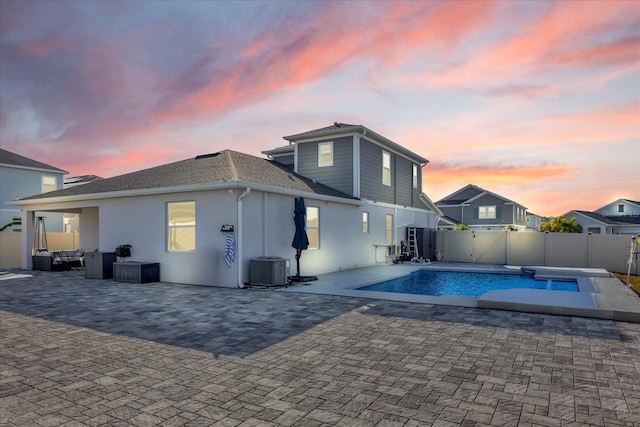 pool at dusk featuring a patio