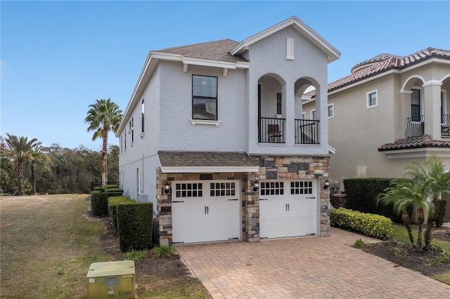 view of front of property with a balcony, a garage, and a front yard