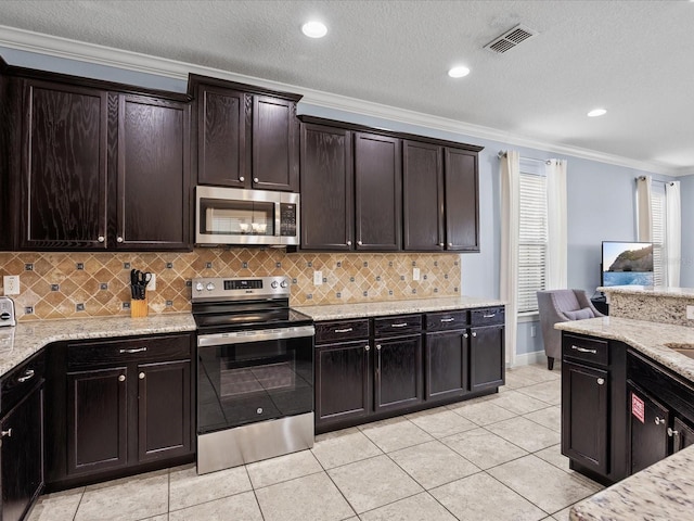 kitchen with light tile patterned floors, crown molding, dark brown cabinets, and stainless steel appliances