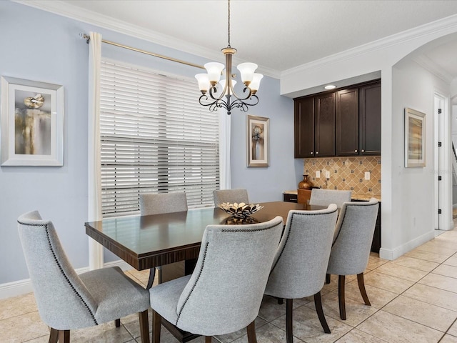 dining room with a notable chandelier, crown molding, and light tile patterned floors