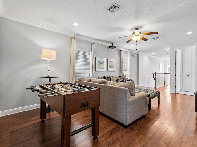 living room with crown molding, dark hardwood / wood-style floors, ceiling fan, and a textured ceiling