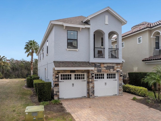 view of front of house featuring a garage and a balcony