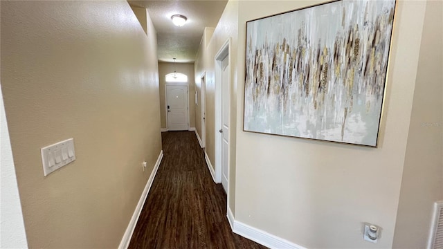 hallway with dark wood-type flooring and a textured ceiling