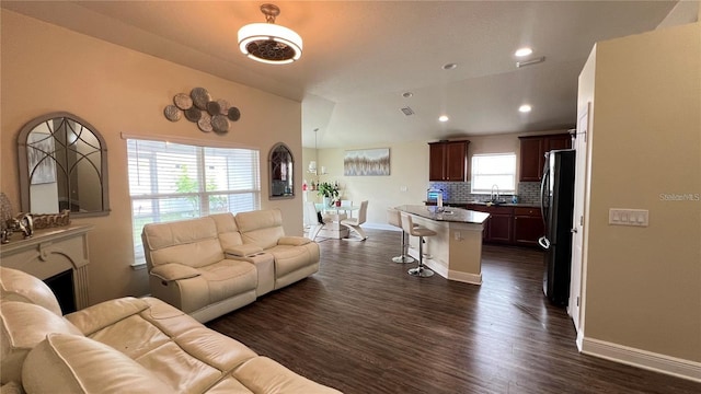 living room featuring sink and dark hardwood / wood-style flooring