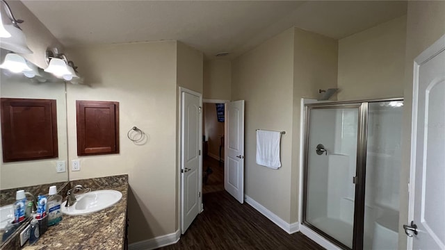 bathroom with vanity, hardwood / wood-style flooring, and a shower with shower door