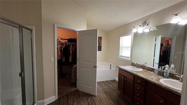 bathroom featuring lofted ceiling, vanity, wood-type flooring, and shower with separate bathtub