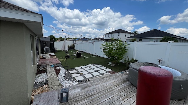 wooden deck with a yard and central air condition unit