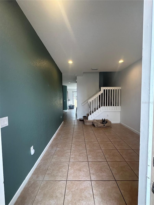 hall with light tile patterned floors