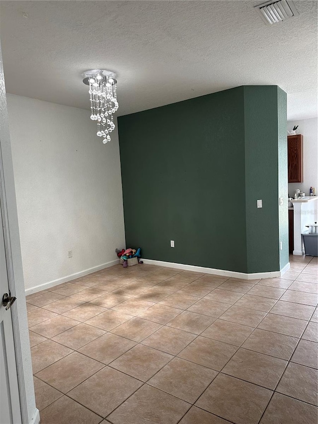 unfurnished dining area featuring light tile patterned floors, a textured ceiling, and a chandelier