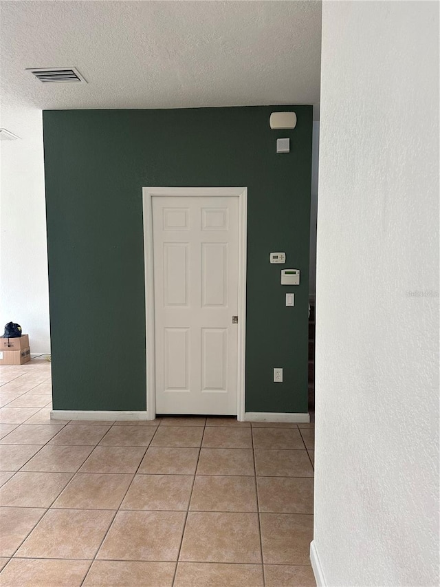 interior space featuring a textured ceiling and light tile patterned flooring